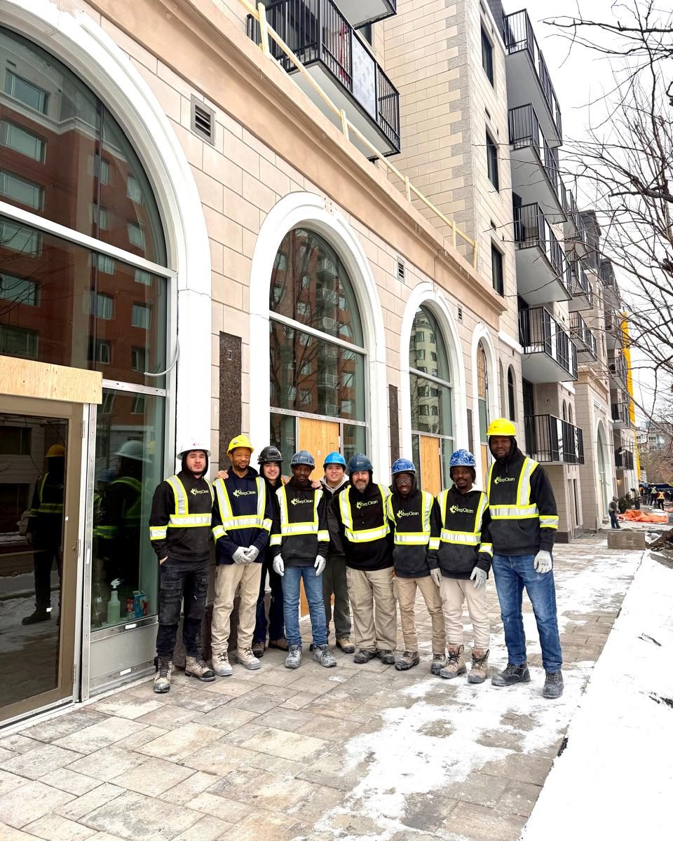 Keep Clean crew members in branded hi-vis hoodies outside a newly finished building