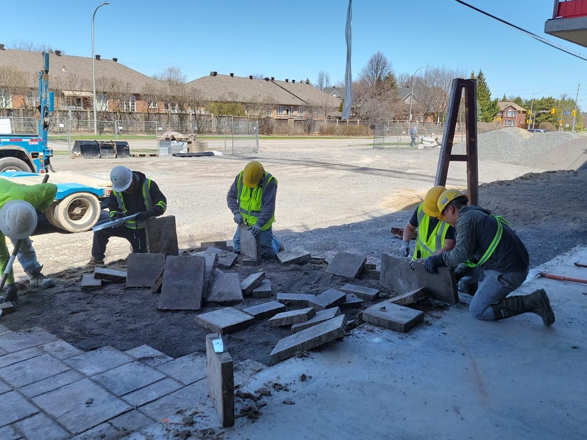 Keep Clean crew laying pavers around a building site