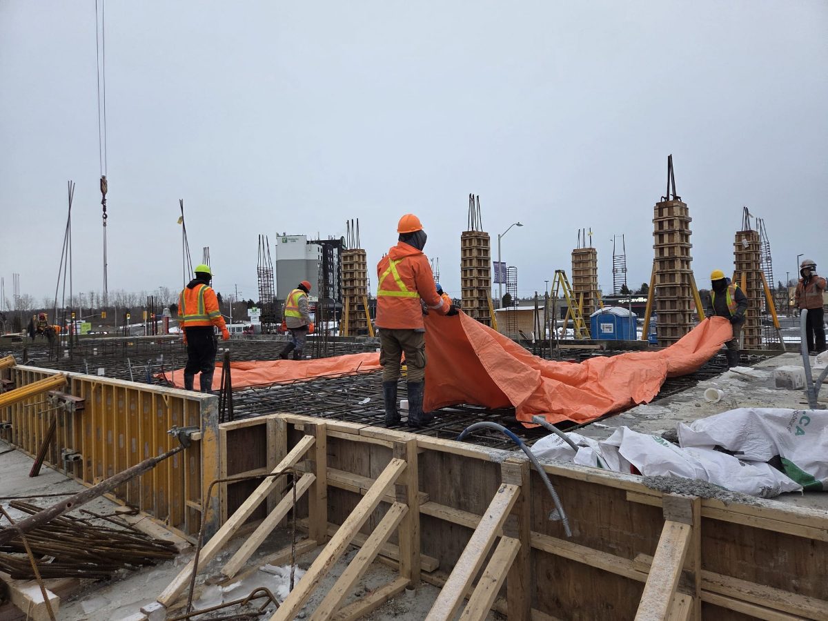 Keep Clean labourers spreading protective tarps over a concrete slab